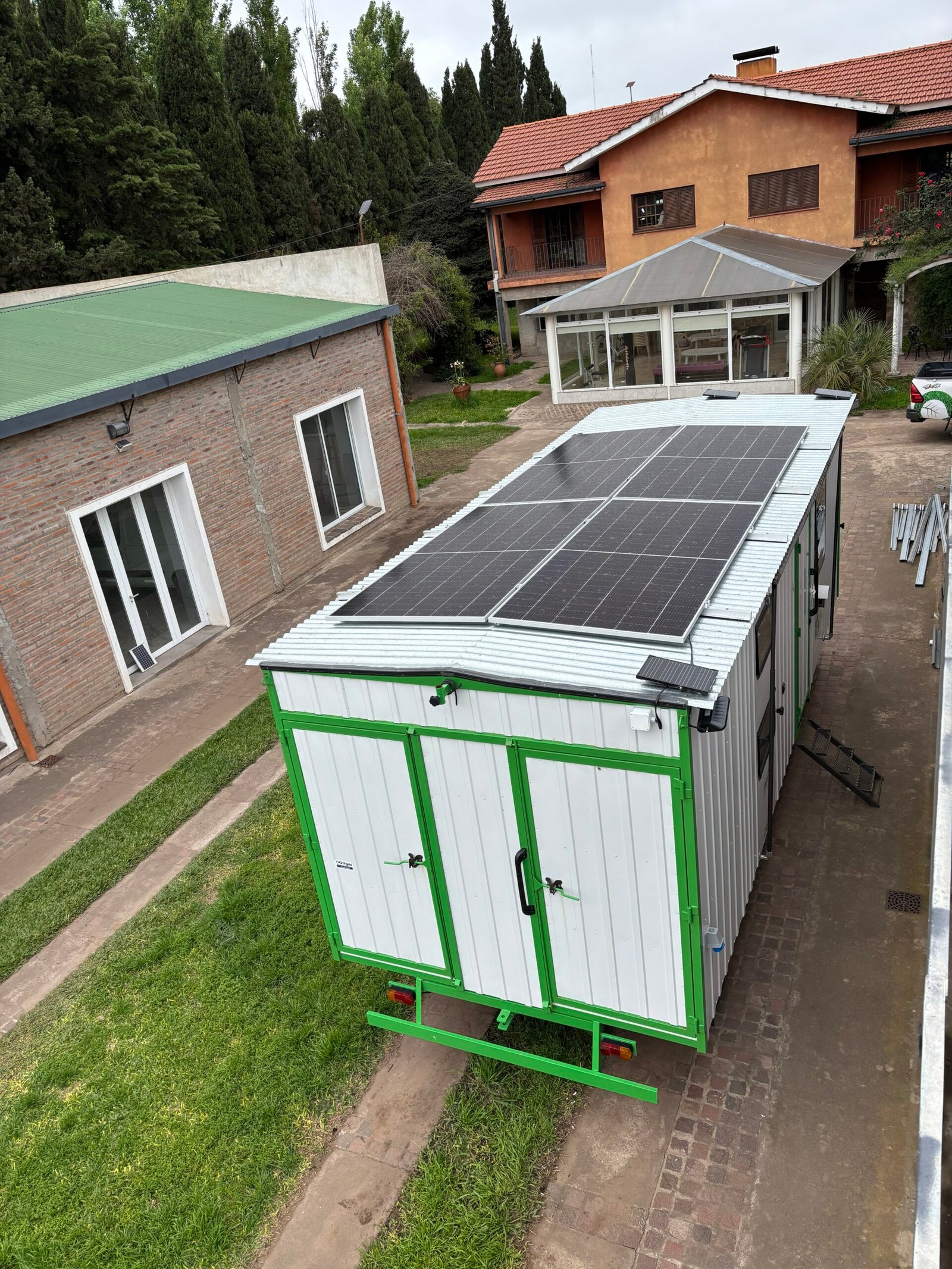 Paneles solares en una instalación rural junto a un tanque de agua.