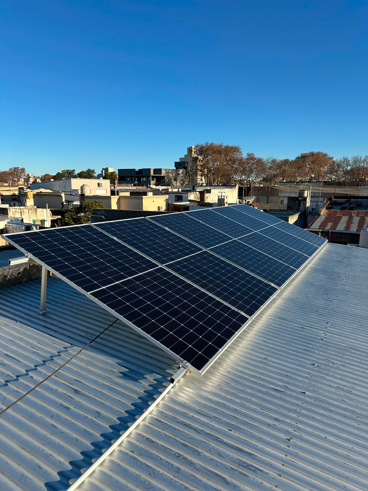 Instalador colocando un panel solar sobre el techo de una vivienda.